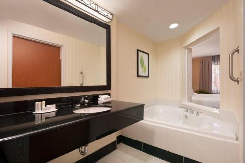 a bathroom with a sink and a tub and a mirror at Fairfield Inn & Suites Redding in Redding