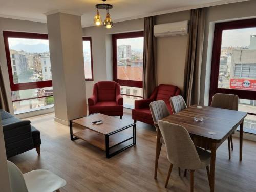 sala de estar con mesa, sillas y ventanas en Royal Homes 404, en Antalya