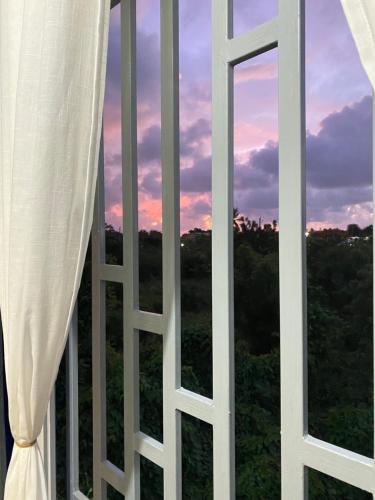 a window with a view of a sunset at Tiny Apartment By Merengue House in Santo Domingo