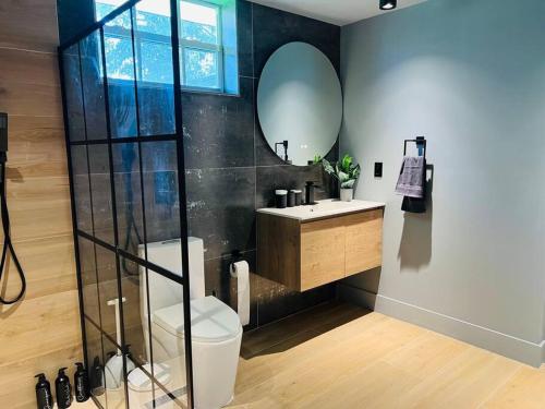 bagno con servizi igienici, lavandino e specchio di Luxurious Designer Miami Retreat 3 Bedroom House a Miami