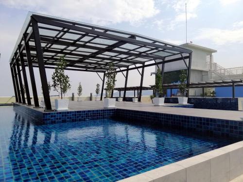 einen Pool mit einer Pergola neben einem Haus in der Unterkunft Sweet Homestay The Venus Sitiawan 温馨民宿 in Sitiawan