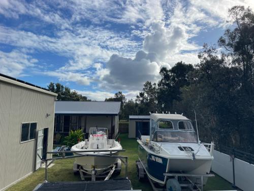 a boat parked in a yard next to a building at 1 Tree Escape in Wooli