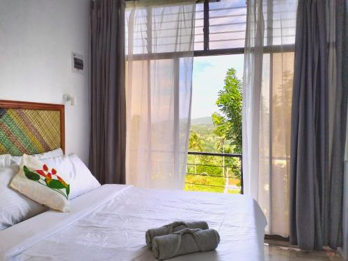 a bedroom with a white bed with a large window at Las Terrazas de Barili in Barili