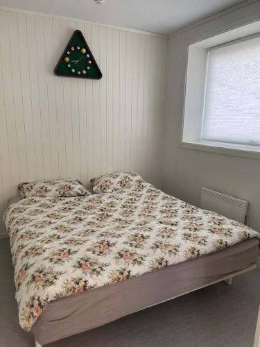 1 dormitorio con 1 cama y reloj en la pared en Lovely apartment with parking in the heart of city, en Lillehammer