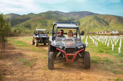 a man and a woman riding in a four wheeler at Indomito Resort & Hotel Boutique in Valle de Guadalupe