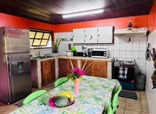una cocina con una mesa con un jarrón de flores. en Fare ManuVai, en Haapu