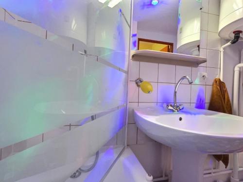 Baño blanco con lavabo y bañera en Ambiance 80 Stranger Things, en Lunéville