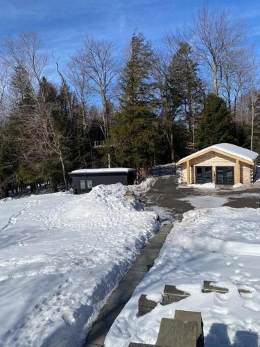 a driveway covered in snow in front of a house at WoodHunterHome in Platte Clove