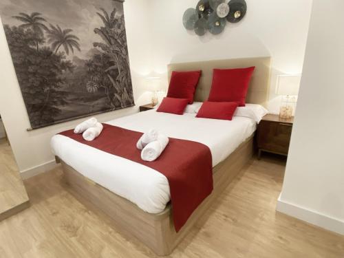 1 dormitorio con 1 cama grande con almohadas rojas en Miramar Luxurious flat, 3 double rooms, free parking, terrace, completely new en San Sebastián