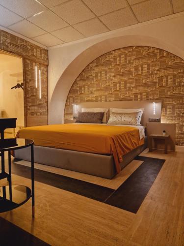 1 dormitorio con 1 cama grande y pared de ladrillo en São Pedro Suite Faro, en Faro
