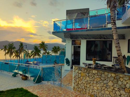 een huis op het strand met een balkon bij Sunset Samana in Las Galeras