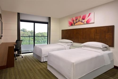 a hotel room with two beds and a desk at Four Points By Sheraton Visakhapatnam in Visakhapatnam