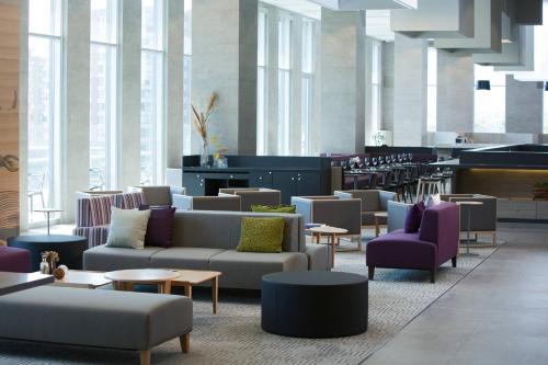 a large lobby with couches and tables and windows at Courtyard by Marriott Santiago Las Condes in Santiago