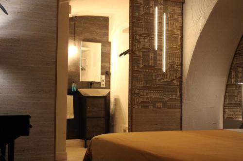 1 dormitorio con cama y pared con espejo en São Pedro Suite Faro, en Faro