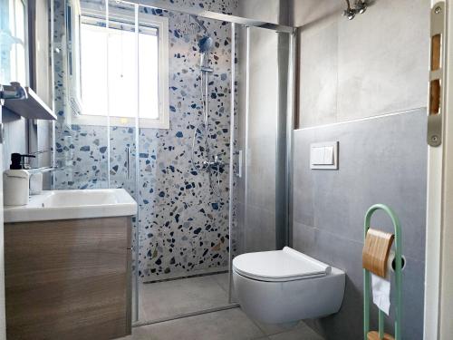e bagno con doccia, servizi igienici e lavandino. di Green Trails Apartment - Fully renovated with mountain view a Divjakë