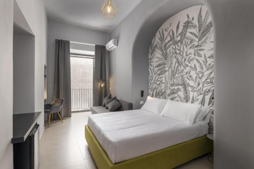 1 dormitorio con 1 cama y una gran pintura en la pared en La Regina del Duomo Catania Centro en Catania