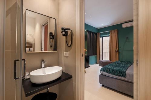 a bathroom with a sink and a bed at La Regina del Duomo Catania Centro in Catania