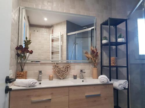 a bathroom with a sink and a large mirror at Apartaments L’ARC in Palafrugell