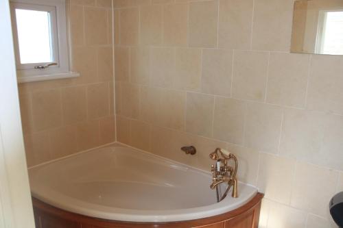 a bath tub in a bathroom with a window at Grays Rest Over, with free parking in Grays Thurrock