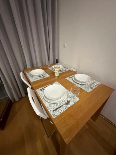 a wooden table with white plates on top of it at Central apartment with balcony in Budapest