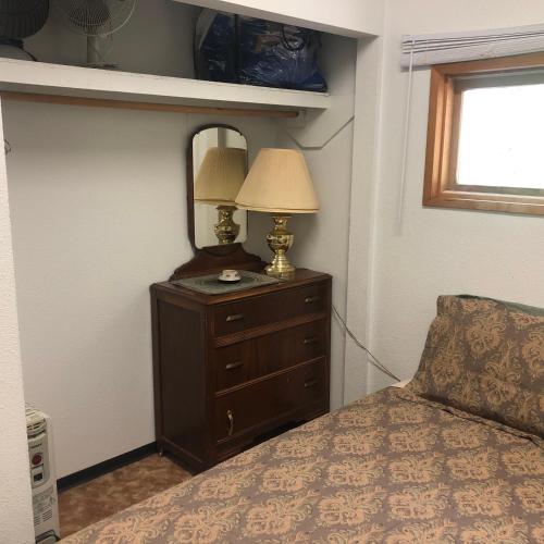 a bedroom with a bed and a dresser with a lamp at Porter’s Place in Vanderhoof