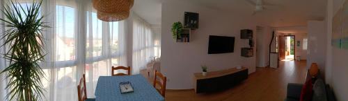 a living room with a blue table and a large window at Precioso apartamento con piscina en la playa in Mogro