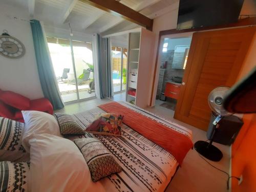 a bedroom with a bed and a large window at bungalow hibis.kiss971 in Baie-Mahault