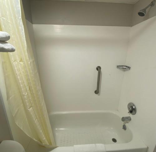 a white bathroom with a tub and a shower at DELUXE INN in Erie