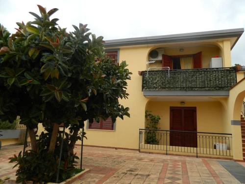 a yellow house with a tree in front of it at Appartamente moderno e accessoriato. in Pula