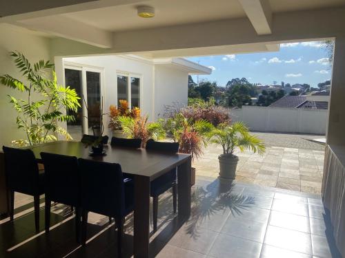 a patio with a table and chairs and plants at Suite residencial, Villa da Luz in Curitiba