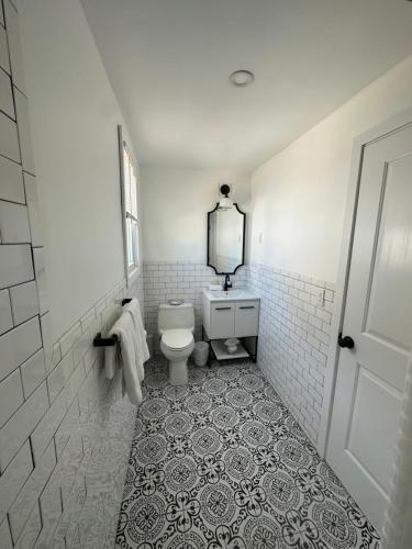 a white bathroom with a toilet and a mirror at Boardwalk Beach Inn in Point Pleasant Beach