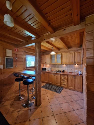 a kitchen with a table and stools in a cabin at Domek Nad Stawem I in Limanowa