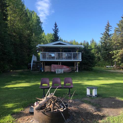 une maison avec deux chaises et un foyer extérieur dans l'établissement Porter’s Place, à Vanderhoof