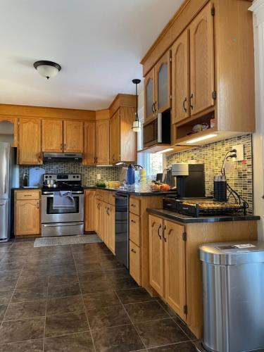 a kitchen with wooden cabinets and stainless steel appliances at Tantallon Guest Room with Private Beach in French Village