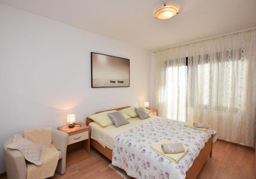 ein Schlafzimmer mit einem Bett, einem Tisch und einem Stuhl in der Unterkunft Apartments Tonja in Primošten