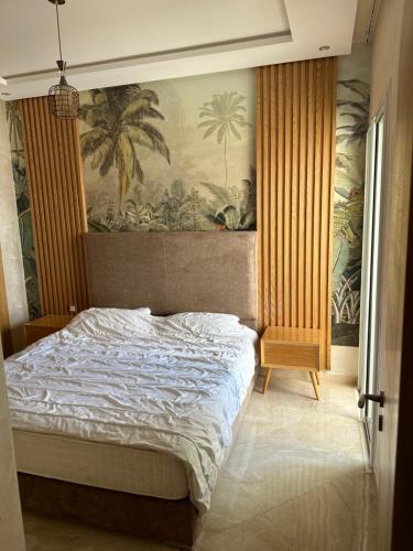 a bedroom with a bed with a painting on the wall at Casa bay sidi rahal in Sidi Rahal