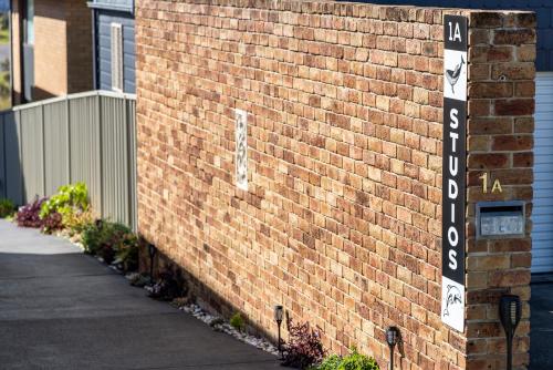 a brick wall with a street sign on it at Whale Studio Suite in Anna Bay