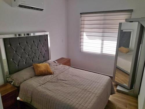 - une chambre avec un lit avec un miroir et une fenêtre dans l'établissement Alojamiento Punta Paraiso 401, à Altata