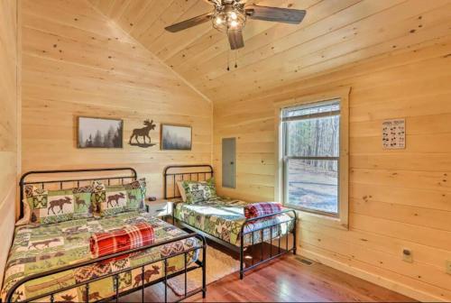 a bedroom with two beds and a ceiling fan at New Serene, Fun & Comfy Cabin- Covered Deck, Grill, Arcade in Murphy