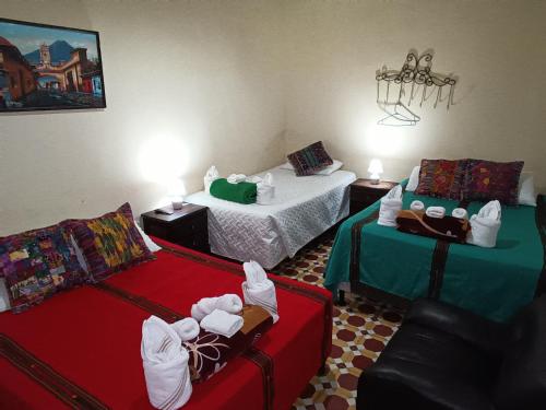 a hotel room with two beds and luggage in it at HOSTAL LA PAZ in Antigua Guatemala
