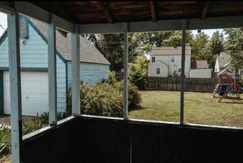 a screened porch with a view of a yard at Bluebird Cottage, walking distance to fairgrounds in Hutchinson