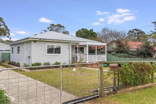 a house with a fence in front of it at Bright and airy cosy cottage, close to town in Thirlmere