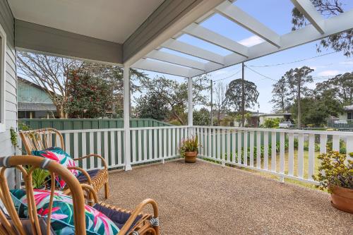 a porch with chairs and a white pergola at Bright and airy cosy cottage, close to town in Thirlmere