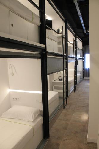 a row of bunk beds in a room at M Pods Malaga in Málaga