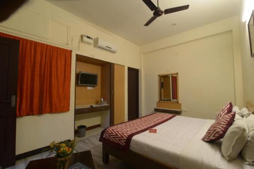 a hotel room with a bed and a ceiling fan at Hotel Kathir Palace in Madurai