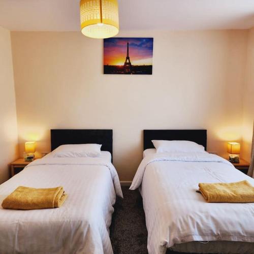 a bedroom with two beds and a picture of the eiffel tower at Sunny South Shields House in Jarrow