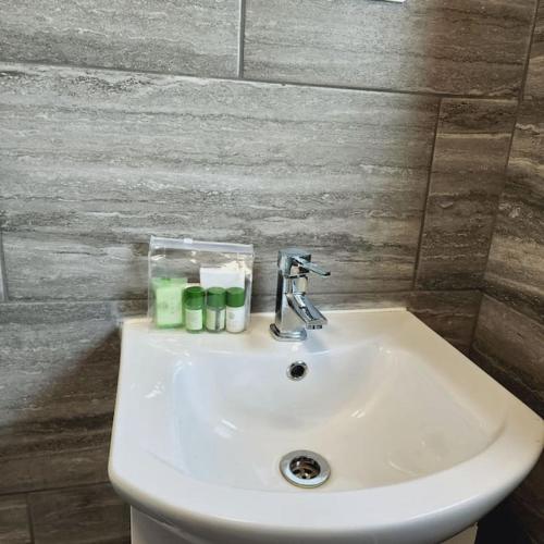 a white sink in a bathroom with a wall at Sunny South Shields House in Jarrow