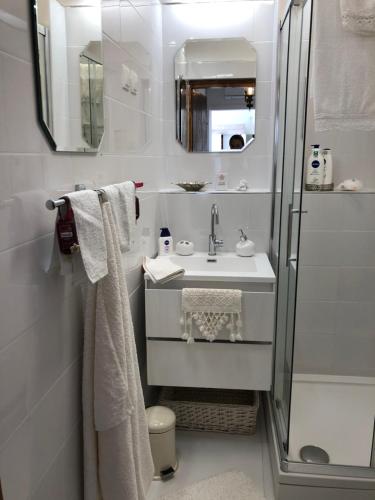 een witte badkamer met een wastafel en een douche bij Happiness in Senj