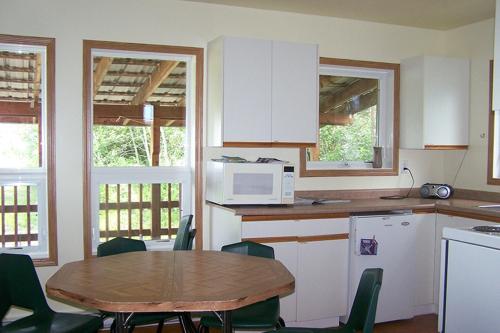 cocina con mesa y microondas en HI Rossburn 9 Finger Ranch en Rossburn
