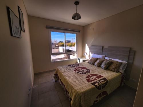 Un dormitorio con una cama grande y una ventana en Riparo Malvinas en Godoy Cruz